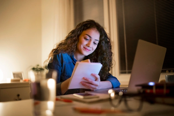 Girl Writing Notes about the GED and how to get it.