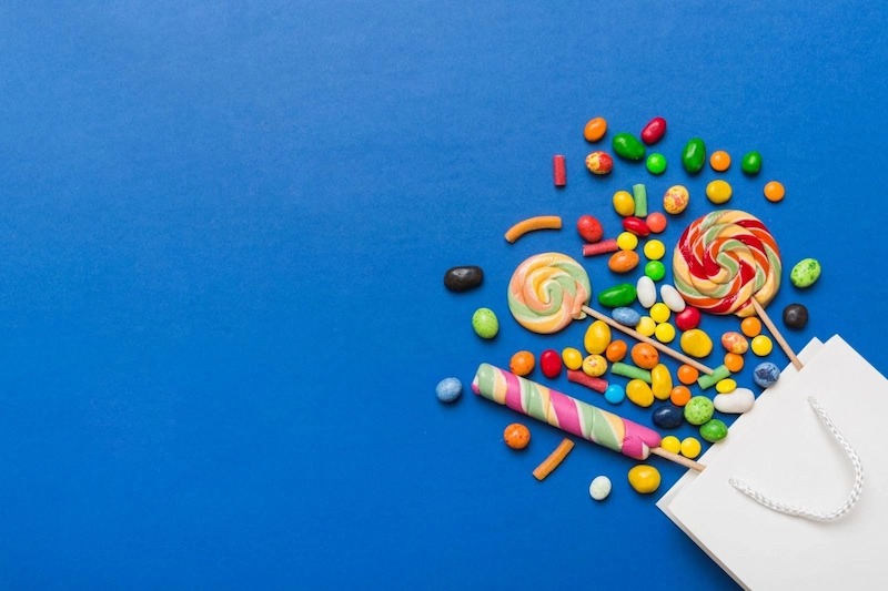 candy spilt out of a bag across a blue table