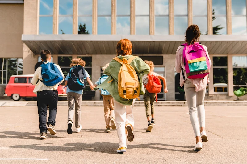 children excited and running to school